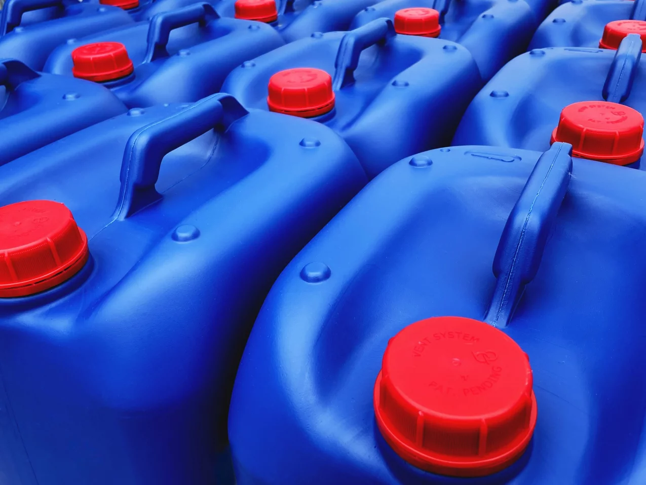 Aufreihung von blauen Kanistern mit roten Deckeln